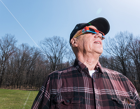 A man views the eclipse through his glasses