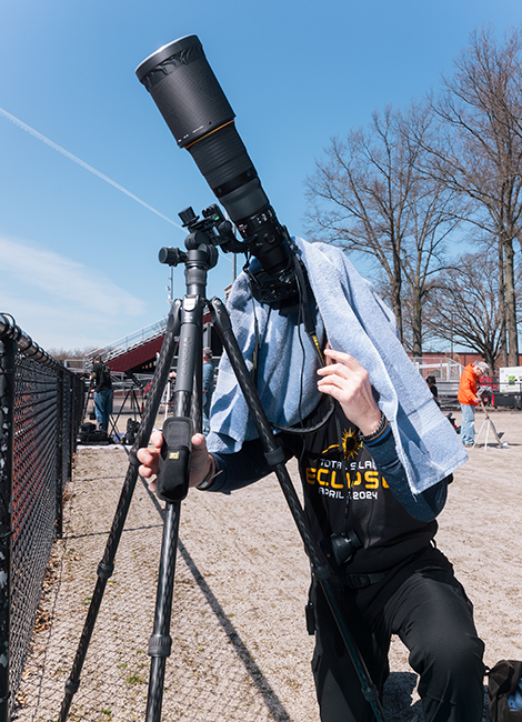 A person views the eclipse through a camera