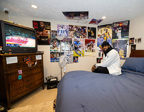 LeBron James sitting in a re-creation of his childhood bedroom at LeBron James' Home Court