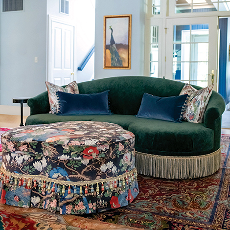 The home's green loveseat and patterned ottoman. 