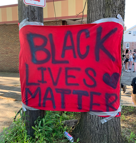 A Black Lives Matter sign hangs next to the West Mini Mart.