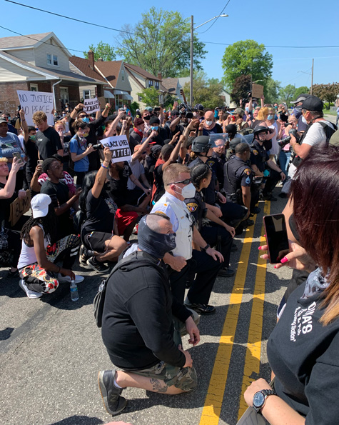 Commander Daniel Fay kneeling with activists.