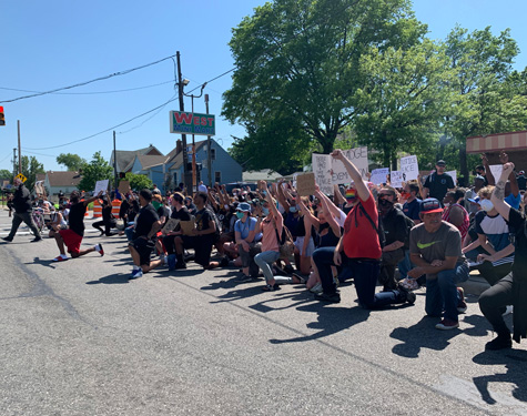Demonstrators kneeling in front of the First District Police Station. Demonstrators kneeling in front of the First District Police Station.