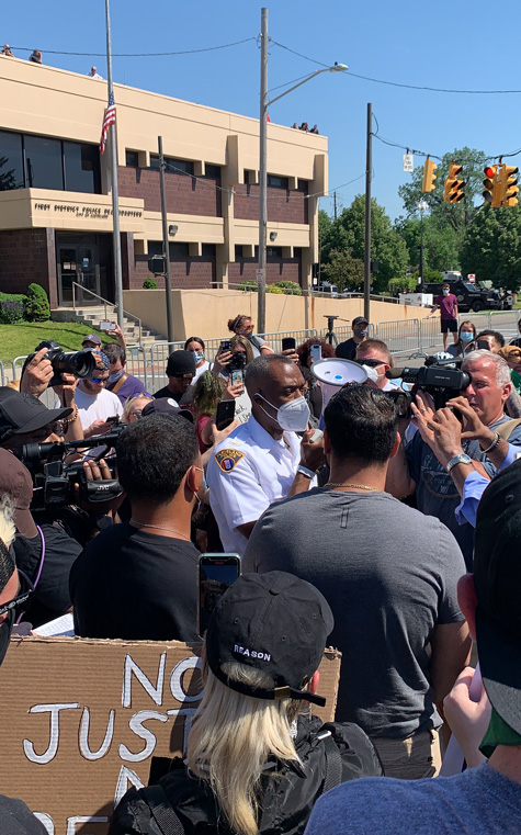 Deputy Chief Wayne Drummond talking to a crowd of protestors.