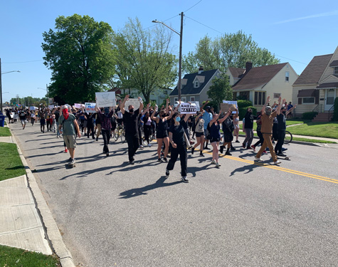 Protestors march down West 130th Street toward Lorain Avenue.