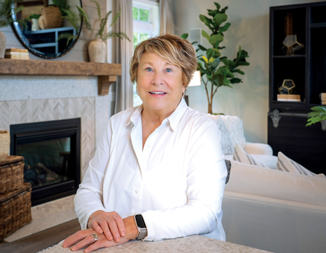 Maurie Jones smiling in front of a fireplace