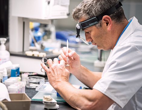 A man in the lab working on a small denture