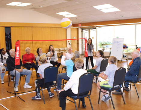 A group of seniors and high school students playing chair volleyball