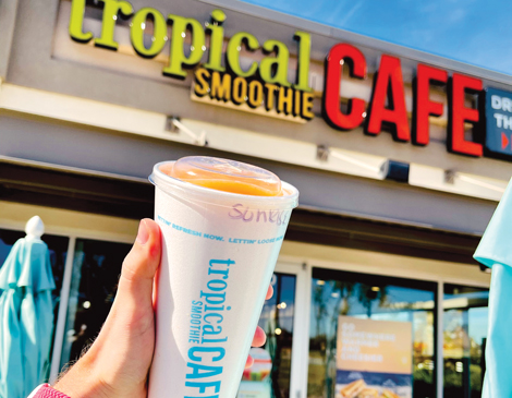 Someone holding a smoothie outside of a Tropical Smoothie Cafe